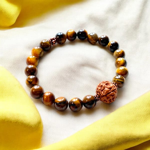 a rudraksha and tiger's eye bracelet on a yellow cloth